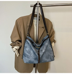 Vintage-Shopper aus gewaschenem blauem Canvas an einem Kleiderbügel mit Freizeitoutfits