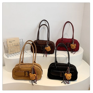 Détail de quatre sacs portés épaule en daim rétro aux couleurs d'automne avec ours