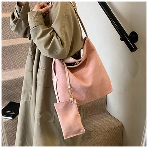 Pink suede tote bag detail with matching accessory pouch on olive green coat