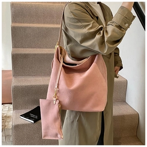 Chic pink matte suede hobo bag with matching coin pouch worn by a model in beige coat