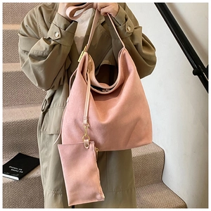Close-up of pink frosted suede tote bag with matching small pendant pouch on a model