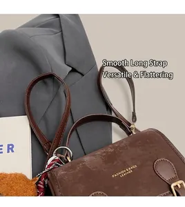 Dettaglio della borsa vintage in pelle marrone con fibbie dorate e stampa fashion