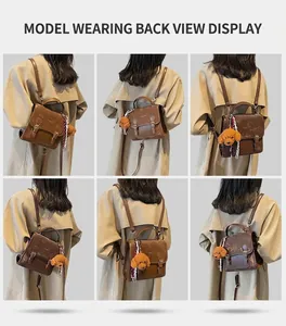 Dettaglio dello zaino vintage in pelle marrone con ciondolo a orsetto e nastro decorativo