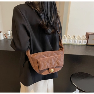 Detail of caramel brown quilted faux leather crossbody bag with golden twist lock