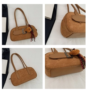 Vue détaillée du sac à main en daim marron avec boucles vintage et pendentif ours