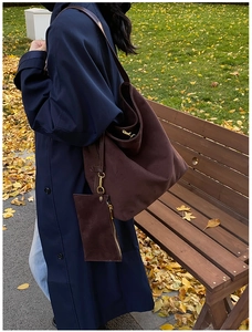 Detail of a large vintage brown faux suede hobo bag with a side coin purse on a model