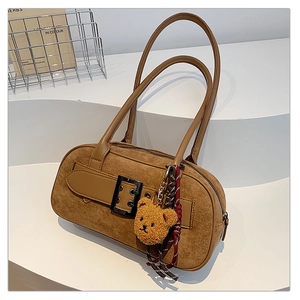 Détail du sac à bandoulière vintage en daim marron avec pendentif ours en peluche