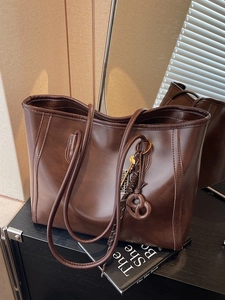 Large dark brown vintage tote bag in soft faux leather with decorative pendant charm