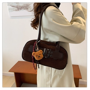 Détail du sac à bandoulière rétro marron foncé avec texture daim et pendentif ours