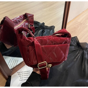 Detail of red quilted gloss shoulder bag with mini pouch and gold hardware accents