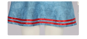 Detailopname van blauwe denimtextuur en rood lint op de circusclownjurk voor dames