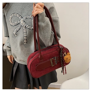 Vue détaillée du sac en daim bordeaux avec boucle vintage et pendentif ours