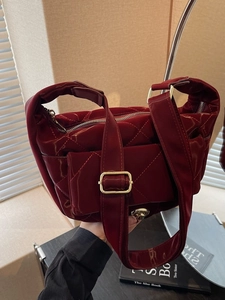 Fashionable dark red quilted patent leather shoulder bag with gold hardware and flap