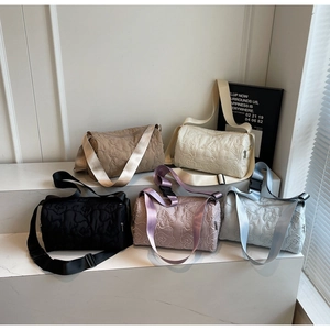 Detail view of five cylinder shoulder bags in various colors with quilted floral patterns