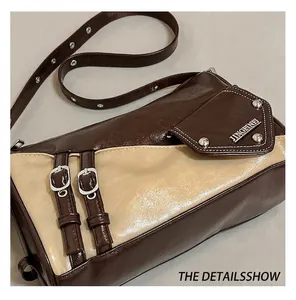 Detail of vintage patchwork shoulder bag with metal buckle and rivet embellishments