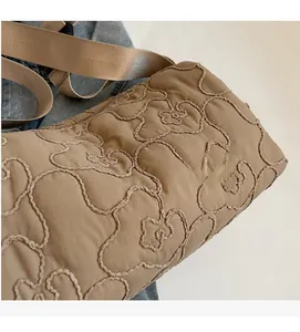 Macro shot of khaki quilted fabric and high-density nylon strap for women's crossbody bag