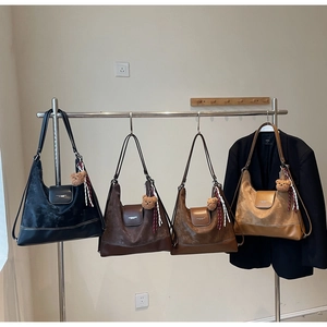 Detail of four colorful suede tote bags with metal buckles and cute bear pendants