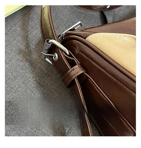 Close-up of retro color-block bag showing precise stitching and metallic buckle details