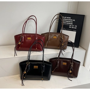 Detail view of glossy oil wax leather bags in burgundy, green, black and brown colors