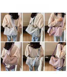 Detail view of quilted puffer shoulder bag featuring 3D floral embroidery in lilac and grey