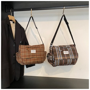 Detail of vintage plaid messenger bags with adjustable straps in two color patterns