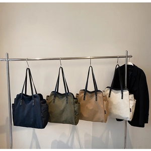 Close-up of canvas tote bags with side pockets and durable black handles in four colors