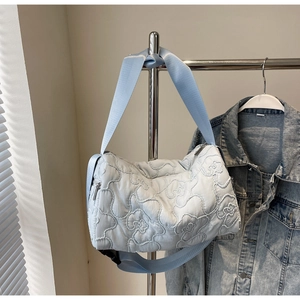 Quilted light blue puffy crossbody bag with 3D floral pattern and nylon shoulder strap