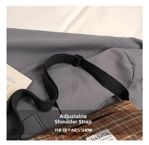 Detail of adjustable black nylon strap with buckle on plaid pattern crossbody bag