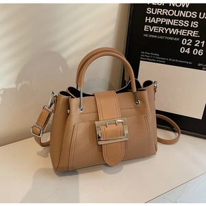 Detail view of the light brown bucket bag featuring fine twill texture and silver buckle