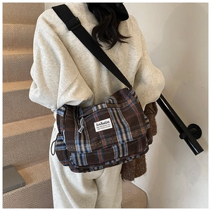 Detail shot of the vintage plaid crossbody bag showing thick tweed texture and fabric strap