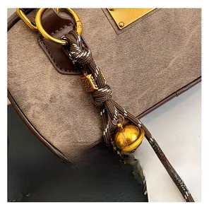 Detail view of vintage crossbody bag with brown fabric and antique gold D-ring hardware