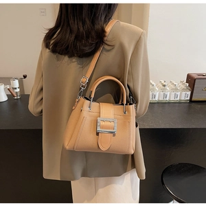 Lifestyle shot of a camel bucket bag with silver buckle and adjustable shoulder strap