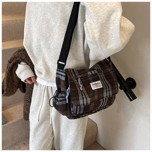 Detail of vintage brown plaid shoulder bag with adjustable strap and designer label