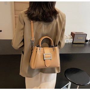 Detail of camel bucket bag showing textured material and silver metal buckle accent