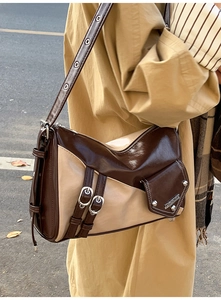 Detail of vintage patchwork shoulder bag with metal buckles and rivet decorations