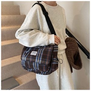 Close-up of vintage check pattern crossbody bag with brand label and adjustable strap