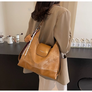 Detail of camel brown large tote bag with bear charm and decorative silk scarf