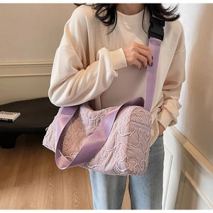 Close-up of lilac quilted crossbody bag featuring 3D floral texture and wide strap