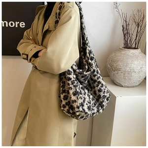 Détail du sac cabas peluche à motif léopard porté avec un trench-coat beige élégant