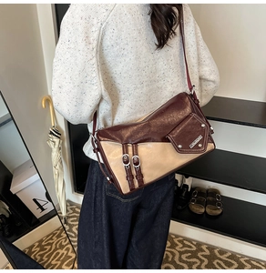 Detail of retro patchwork underarm bag with silver buckle and dark red leather texture