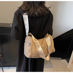 Detailed embroidery and quilted floral pattern on large khaki canvas crossbody bag