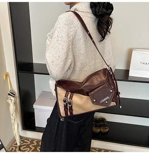 Detail of vintage contrast pillow bag showing burgundy leather texture and metal buckle