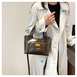Vue détaillée du sac seau rétro en cuir PU marron foncé avec logo et bandoulière