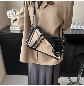 Detail of vintage patchwork shoulder bag with silver buckles on beige and black leather
