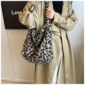 Grand sac cabas en peluche imprimé léopard porté par un mannequin en trench-coat chic