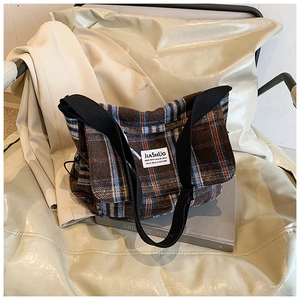 Detail of vintage brown plaid tweed shoulder bag with JIASHUO label and woven strap