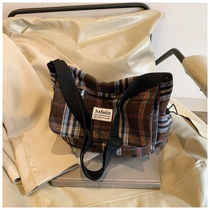 Macro detail of the vintage plaid shoulder bag with JIASHUO woven label on tweed fabric