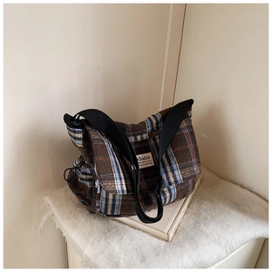 Detail of checkered crossbody bag with adjustable drawstrings and SHUO brand tag