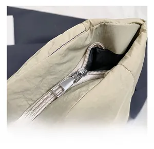 Close-up of the smooth metal zipper and inner lining detail of the beige tote bag