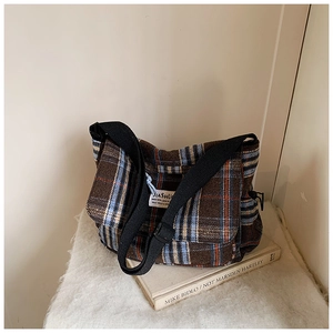 Detail of vintage check plaid texture and branding label on a wool shoulder bag